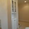White bathroom cabinet with upper glass doors and bottom raised panel doors